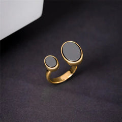 ANEL DE REGULAGEM DOURADO EM HEMATITA OVAL DUAS PEDRAS